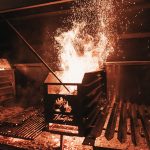 Photo of charcoal being ignited with sparks flying through the air